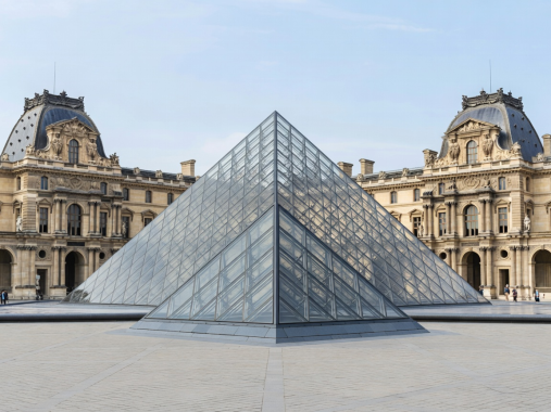Courtyard of the Louvre museum showing the glass pyramid and historic classical stone wings